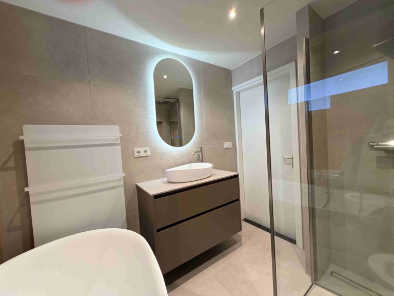 Wastafel met waskom, rvs kraan en ovale LED-spiegel op taupe meubel