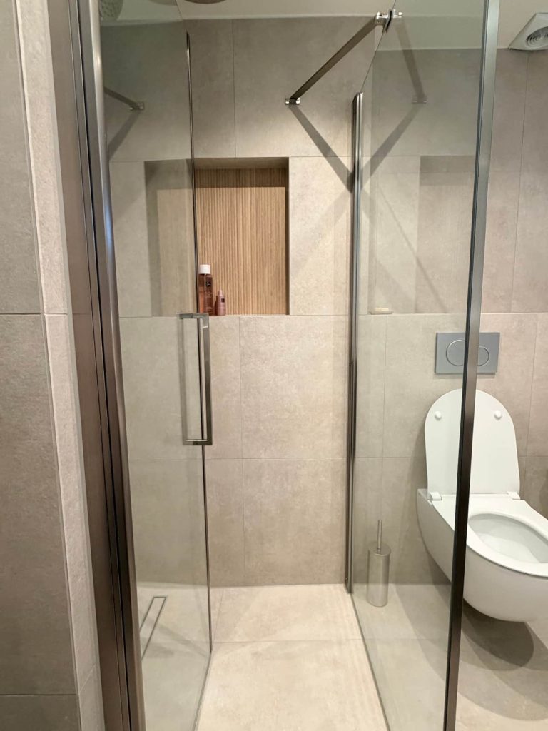 Inloopdouche met glazen wand en ingebouwde nis met houtlook achtergrond