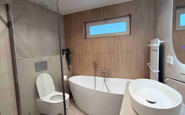 Moderne badkamer met vrijstaand bad, inloopdouche en wastafel met natuursteenblad