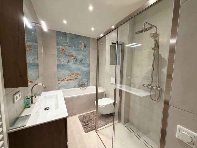Compacte badkamer in Eindhoven met bad, inloopdouche en blauwe onyx-look tegel na renovatie