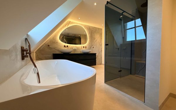 Overzicht van badkamer renovatie in Helmond met vrijstaand bad, inloopdouche met rookglas en dubbele wastafel onder schuin dak