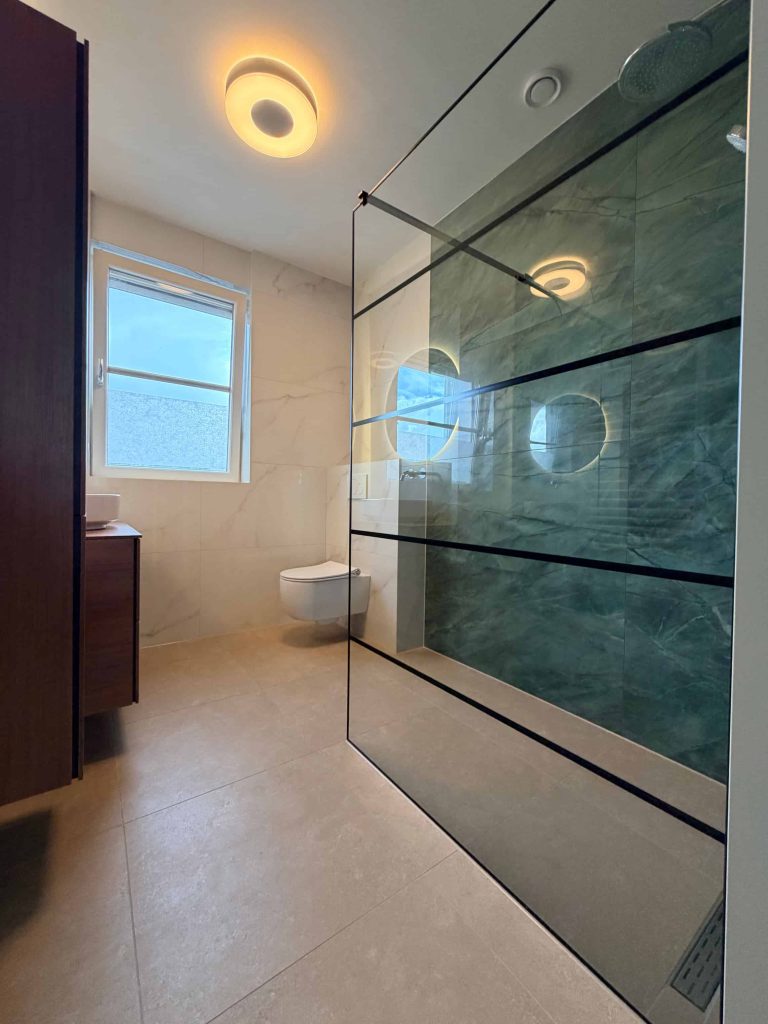 Detail van groene natuursteenlook tegel met grijze aders in badkamer Valkenswaard