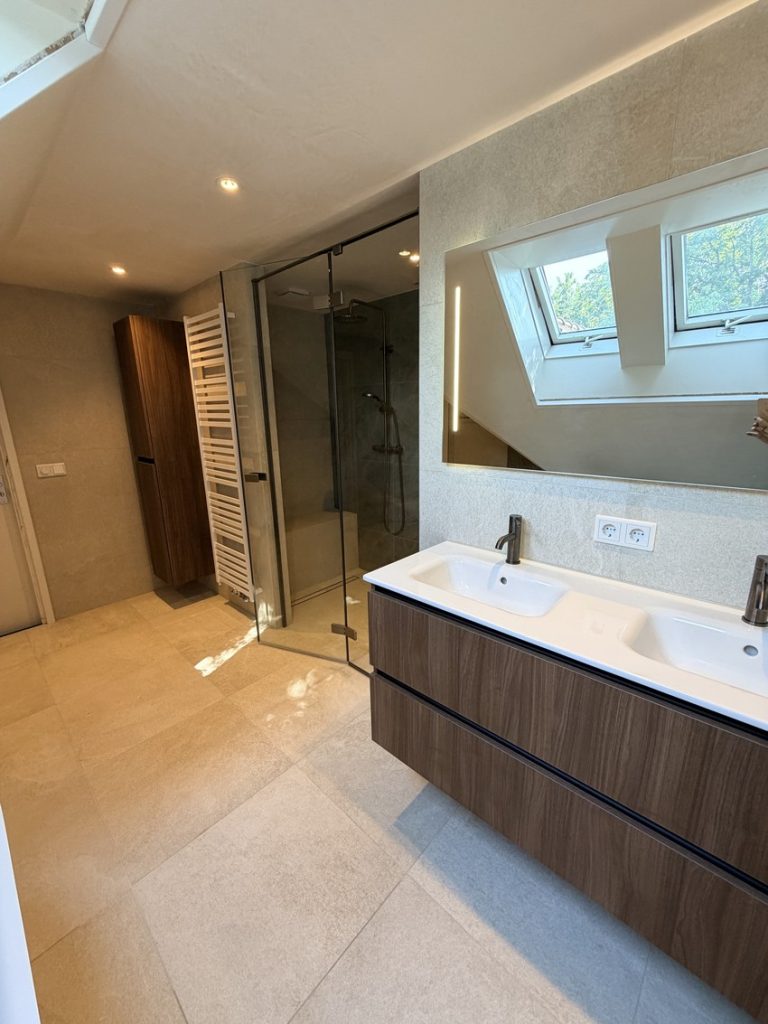 Dubbele wastafel op houtlook badmeubel met spiegel met verlichting en dakramen