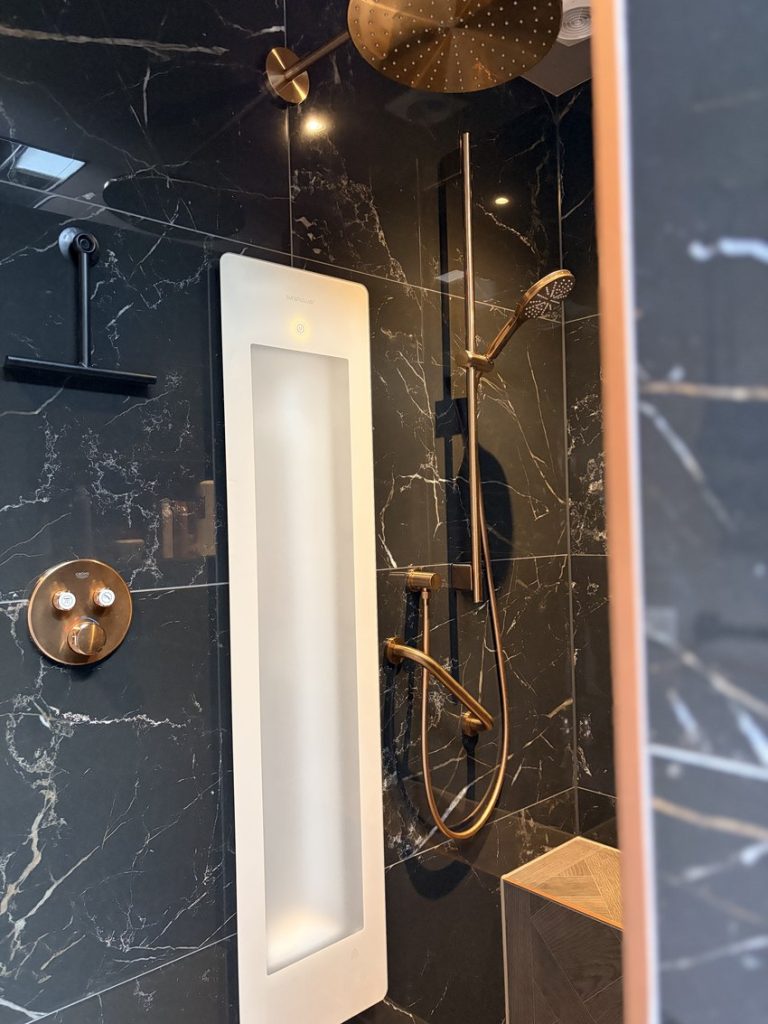Koperkleurige Grohe inbouwthermostaat en Sunshower-paneel in de inloopdouche